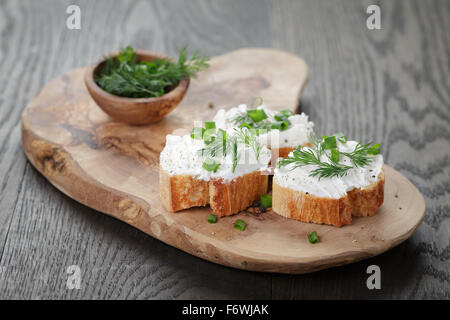 Baguette croccanti fette con la crema di formaggio ed erbe aromatiche Foto Stock