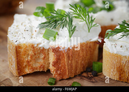 Baguette croccanti fette con la crema di formaggio ed erbe aromatiche Foto Stock