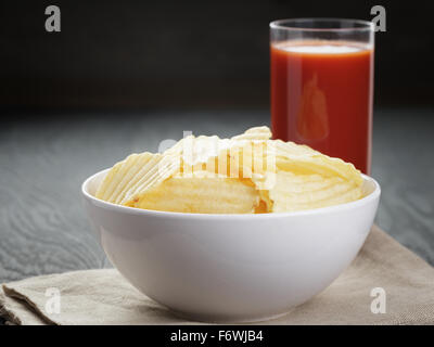 Increspata chip organico nella ciotola bianco wit di succo di pomodoro Foto Stock