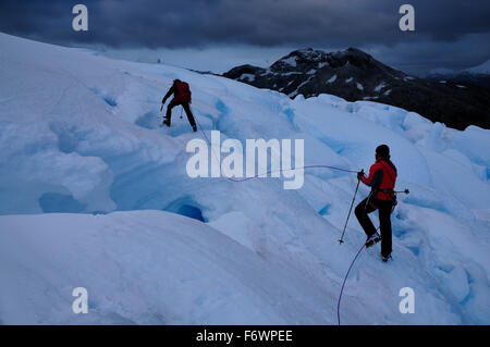 Due alpinisti passando un ghiacciaio, Monte Sarmiento, Cordillera Darwin, Tierra del Fuego, Cile Foto Stock