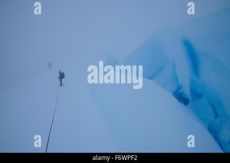 Due alpinisti in un whiteout su un ghiacciaio sotto il Monte Sarmiento, Cordillera Darwin, Tierra del Fuego, Cile Foto Stock