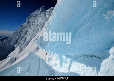 Alpinista nel bergschrund della parete nord del monte Sarmiento, Cordillera Darwin, Tierra del Fuego, Cile Foto Stock