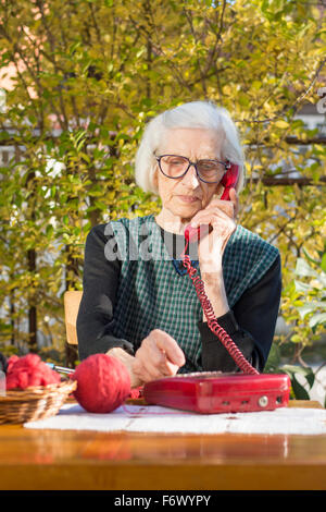 Novanta anni nonna parlando al telefono nel cortile posteriore Foto Stock