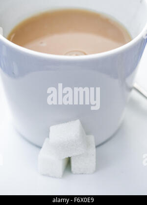 White zollette di zucchero con una tazza di tè Foto stock - Alamy