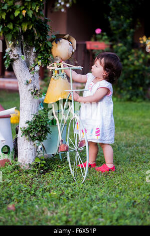 Bambina giocando con giardino giocattoli su erba verde. Foto Stock