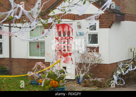 Halloween casa decorata con le parole "Tenere fuori' in rosso sulla porta anteriore. Zucche e fake spider web e mani scheletriche. Foto Stock