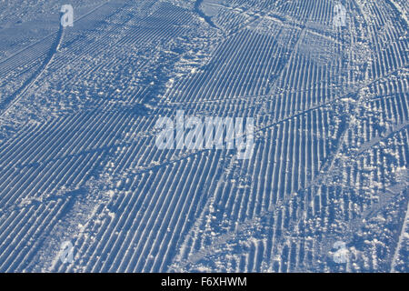 Neve fresca toelettatore tracce su una montagna piste da sci Foto Stock