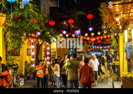 HOI AN, VIETNAM - Febbraio 26, 2015: Bright Lampions appesa sopra la strada pedonale nel centro storico della città di Hoi An di notte con molti turisti che vanno in giro ci. Foto Stock