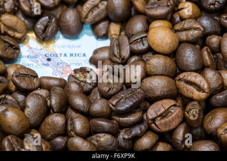 Mappa geografica della Costa Rica coperto da uno sfondo di chicchi di caffè tostati. Questa nazione è uno dei principali produttori e exp Foto Stock