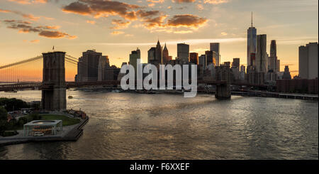 Abbassare i grattacieli di Manhattan e il distretto finanziario skyline al tramonto con il ponte di Brooklyn oltre l'East River, New York CIty