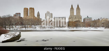 Inverno mattina dopo la nevicata nel Central Park e il lago ghiacciato. Manhattan Upper West edifici si ergono al di sopra del Park di New York City Foto Stock