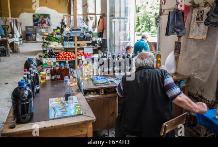 Uomo in casa vendita chacha e vino sul mercato a Sighnaghi town nella regione di Kakheti, Georgia Foto Stock