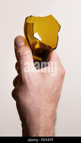 Ripresa dall'alto di una mano di un uomo in possesso di un vetro rotto bottlen in modo minaccioso Foto Stock