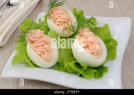 Uova ripiene di pâté di salmone in foglie di lattuga Foto Stock