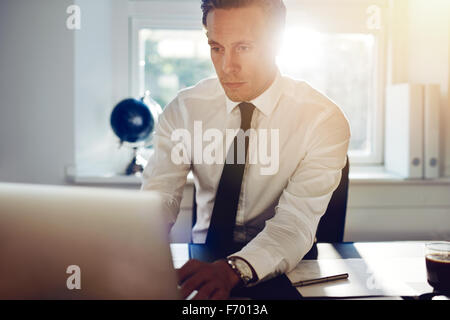 Bianco giovane uomo business lavorando sul computer seduto alla sua scrivania Foto Stock