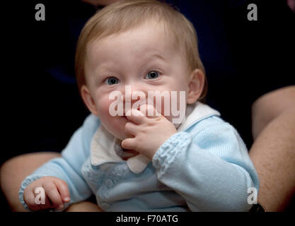 Generazioni. Un giovane bambino è seduto sulla sua bisnonna ginocchio essendo mantenuto sicuro e sicuro. Foto Stock