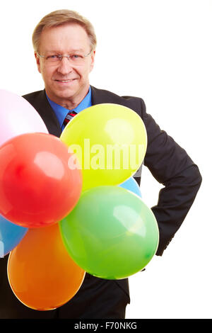 Happy businessman senior azienda molti palloncini colorati Foto Stock