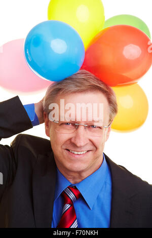 Happy businessman senior azienda molti palloncini colorati Foto Stock