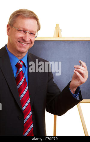 Imprenditore Senior in un abito di fronte a una lavagna Foto Stock