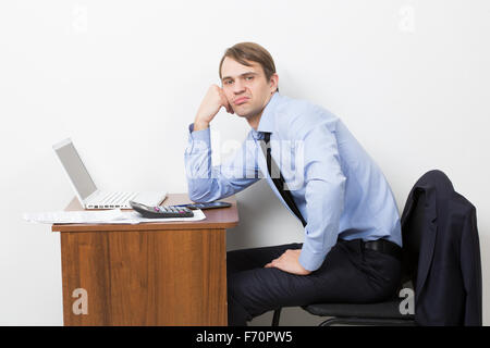 Lavoratore di ufficio prende pausa dal suo lavoro. Egli è seduto con faccia acida Foto Stock