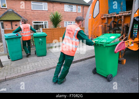 Binmen la raccolta di rifiuti dal quartiere degli scomparti di wheelie e caricarli nel carrello di polvere, Foto Stock