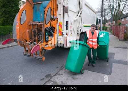 Binman la raccolta di rifiuti dal quartiere degli scomparti di wheelie e caricarli nel carrello di polvere, Foto Stock