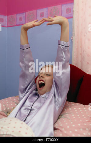 Ragazza di svegliarvi e stretching, Foto Stock