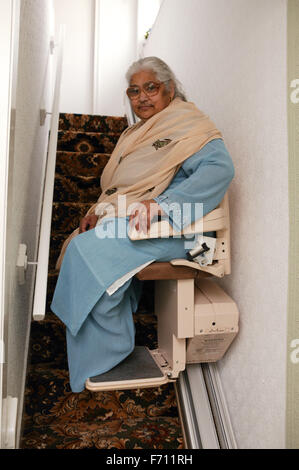 South Asian lady utilizzando una scala di sollevamento, Foto Stock