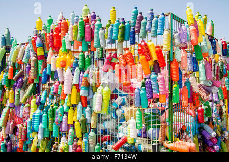 Bottiglie di plastica e contenitori preparati per il riciclaggio in un colorato contenitore di riciclaggio Foto Stock