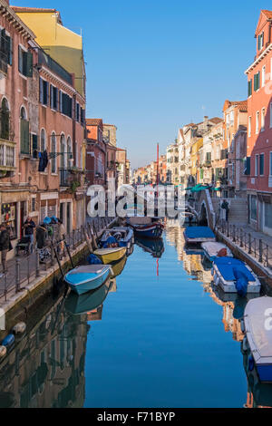 Venezia, Italia. Rio di Sant'Anna canal rivestiti con le tipiche case in stile veneziano, negozi e case, barche e cielo blu Foto Stock