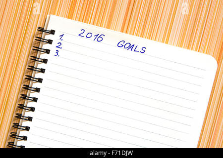 Notebook con gli obiettivi dell'anno 2016 su striped sfondo arancione Foto Stock