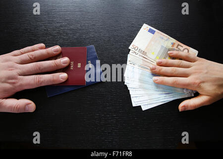 L'acquisto illegale di passaporto straniero mani lo scambio di denaro e documenti acquirente e venditore Foto Stock