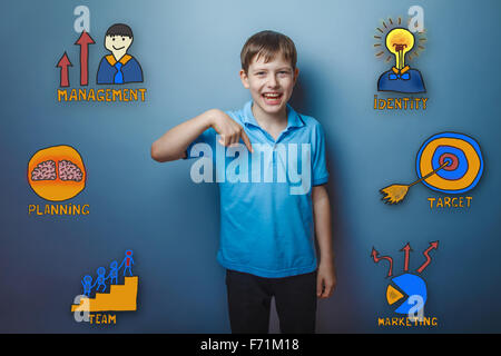 Teen boy punta il dito verso il basso e ridere gioia raccolta di b Foto Stock