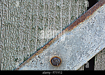 Primo piano della testa grossa vite di metallo sul piatto di legno Foto Stock