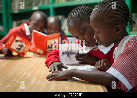 Giovani bambini kenioti pratica buddy lettura durante un esercizio di classe a Nostra Signora di Nazareth scuola Maggio 6, 2013 a Nairobi in Kenya. Foto Stock