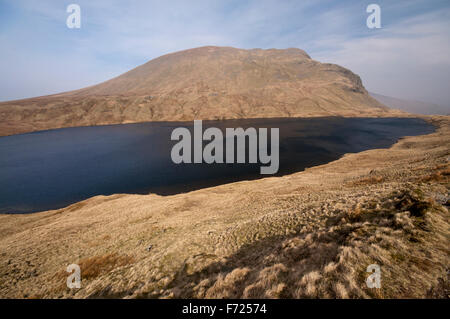 Un ventoso Grisedale Tarn nel Parco Nazionale del Distretto dei Laghi. Torreggiante sopra, Dollywagon Pike vige torreggiante sopra il Tarn. Foto Stock