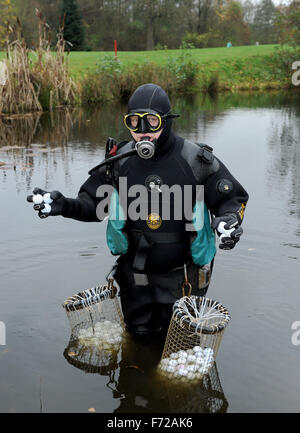 Bremen, Germania. Decimo Nov, 2015. Palla da golf subacqueo Ralf Oestmann detiene il self-made cesti riempiti con palline da golf nelle sue mani su un campo da golf a Bremen, Germania, 10 novembre 2015. Oestmann pesci per perdita di palline da golf sul campo da golf che pulisce e rivende. Foto: Ingo Wagner/dpa/Alamy Live News Foto Stock