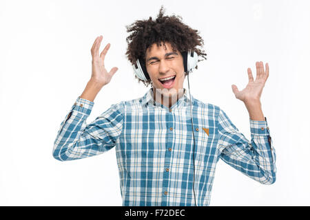 Ritratto di un allegro afro american uomo che ascolta la musica nelle cuffie isolato su uno sfondo bianco Foto Stock