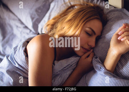 Bella donna che dorme nel letto Foto Stock