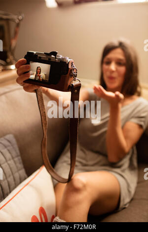 Donna felice tenendo selfie con la fotocamera Foto Stock