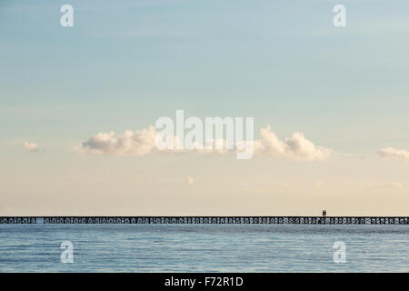 Persone da Bajo villaggio sulle isole Togean attraversando il ponte alla terraferma, Indonesia. Foto Stock