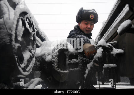(151124) -- ZHENGZHOU, nov. 24, 2015 (Xinhua) -- Un personale ferroviario tunes parti del treno in corrispondenza di Xinxiang stazione ferroviaria in Xinxiang, centrale cinese della Provincia di Henan, nov. 24, 2015. Nevicata a partire da lunedì ha causato alcune tratte ferroviarie ritardo nella Provincia di Henan. (Xinhua/Wang Huan) (DHF) Foto Stock
