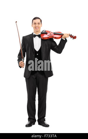 A piena lunghezza Ritratto di un elegante giovane musicista tenendo un violino e guardando la telecamera isolata su sfondo bianco Foto Stock