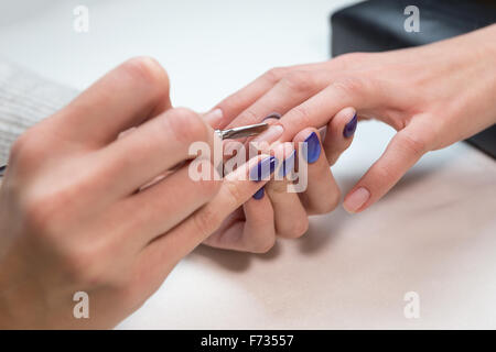 Rimozione Manicurist cuticola con spintore in metallo Foto Stock