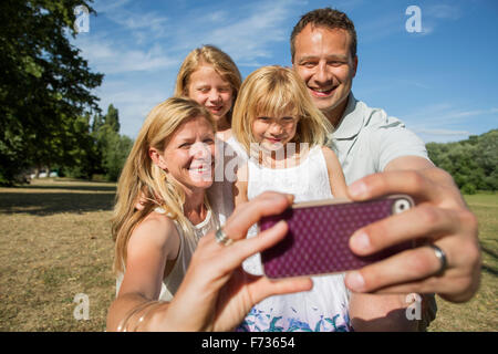 Famiglia con due bambini, prendendo un selfie. Foto Stock