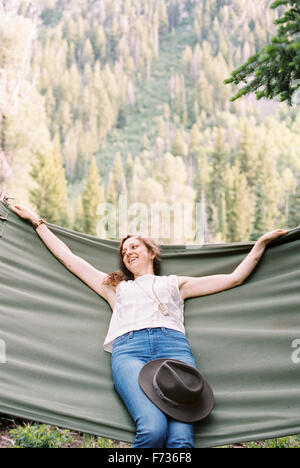 Donna rilassante in una grande amaca in una foresta. Foto Stock