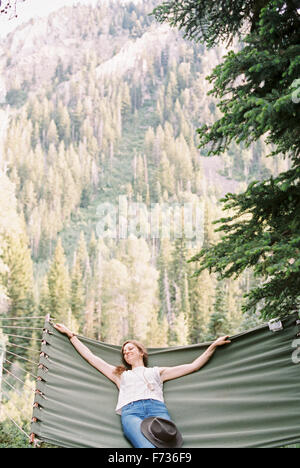 Donna rilassante in una grande amaca in una foresta. Foto Stock