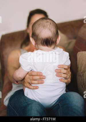 Una donna che tiene una bambina sul suo ginocchio. Foto Stock