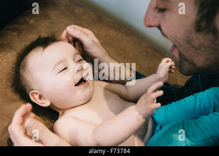 Un uomo e un bimbo piccolo guardando ogni altro e ridere. Foto Stock