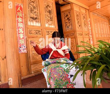 Yulong cinese della provincia dello Yunnan. 24 Novembre, 2015. Una donna di Naxi locale gruppo etnico non ricamo a casa in Tianhong Village, situato ad una altitudine di circa 3000 metri, in Yulong Naxi contea autonoma, a sud-ovest della Cina di Provincia di Yunnan, nov. 24, 2015. © Yang Zongyou/Xinhua/Alamy Live News Foto Stock